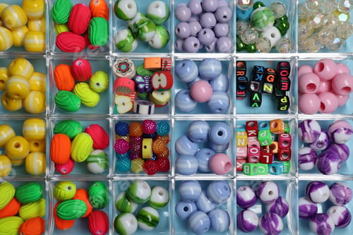 Preview: Box with different colorful beads on light blue background, top view