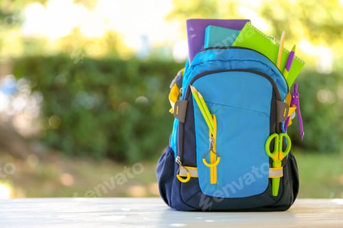 Preview: Backpack with school stationery on table outdoors