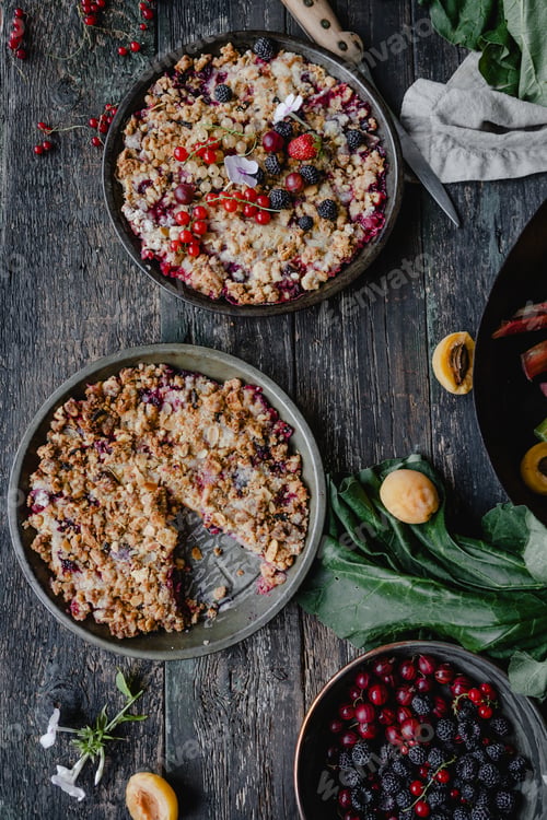 Preview: elevated view of tasty pies with berries on wooden table