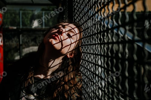 Preview: A girl closes her eyes with shadows on her face