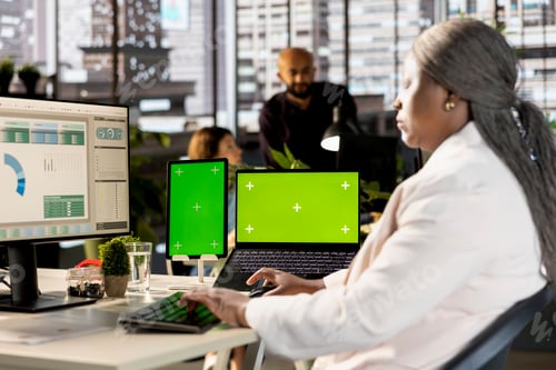 Preview: Business professional working on financial report next to chroma key screen