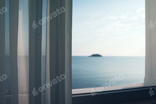 Preview: small ocean island seen through a window with transparent fabric curtains