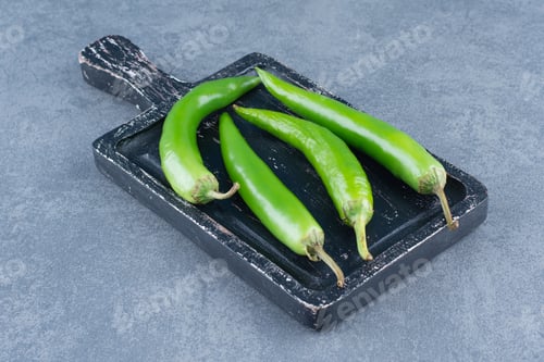 Preview: Green chili peppers on wooden board