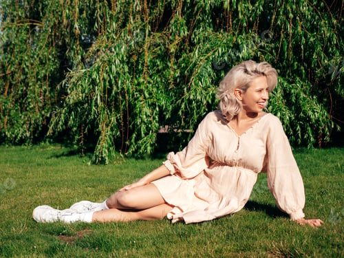 Preview: Young beautiful smiling blond woman posing outdoors