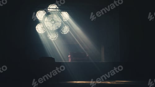 Preview: Streams through a flower shaped window into a dark room with a -table