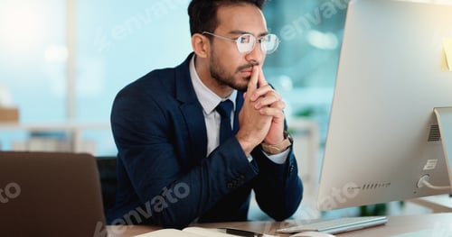 Preview: Thinking IT manager working on a desktop computer and laptop in a modern office. Information Techno