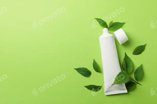 Preview: Toothpaste tube and mint leaves on green background, space for text