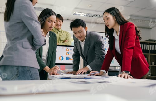 Preview: Asian business people analyzing charts and reports in a meeting room