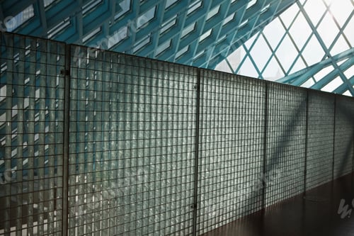 Preview: A building interior, with sloping glass roof and grid panels and polished floor
