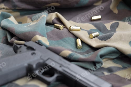 Preview: 9mm bullets and pistol lie on folded camouflage green fabric