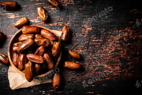 Preview: Delicious dates on a wooden plate.