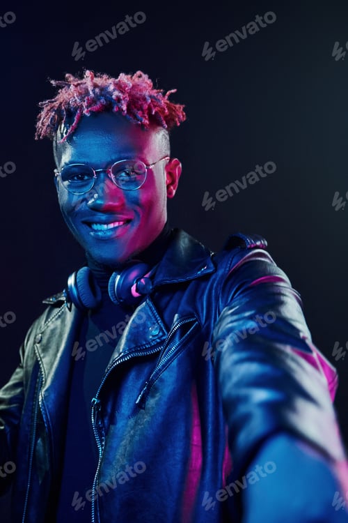 Preview: Futuristic neon lighting. Young african american man in the studio