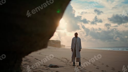 Preview: Ocean shore woman silhouette posing in sunlight. Stylish girl coming out cliff