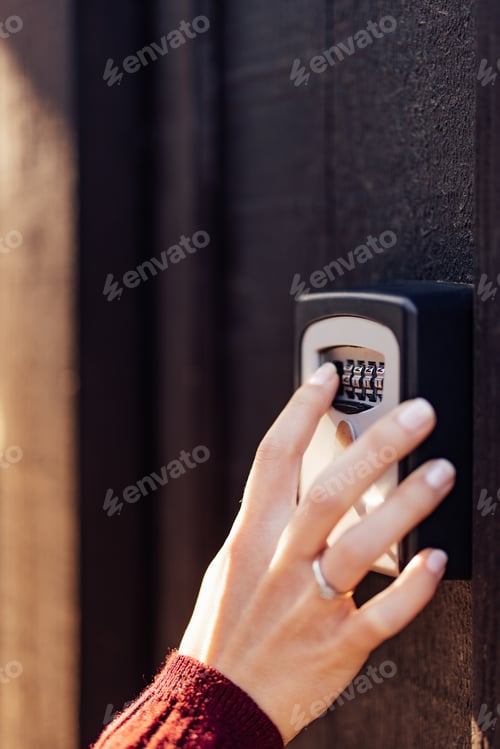 Preview: Person Unlocking a Combination Safe Box on a Wooden Surface