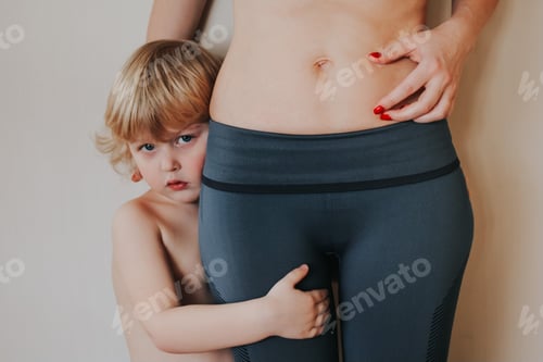 Preview: A beautiful young woman with child showing her imperfect belly after pregnancy. She feeling fat. N