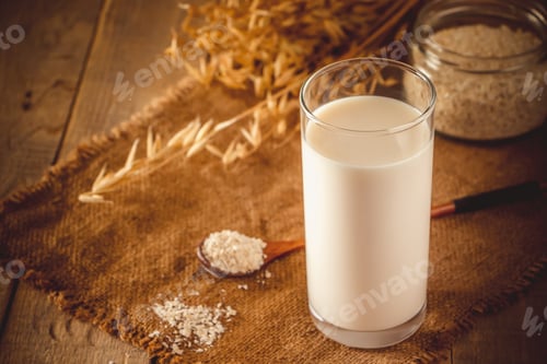 Preview: Glass of oat milk on a wooden background.