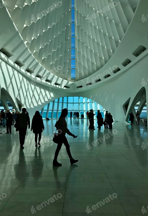 Preview: Silhouettes of people walking and standing in the lobby of the Milwaukee Art Museum