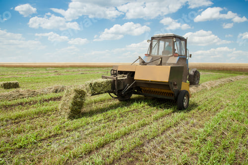 Preview: Tractor collects dry hay on the farm field