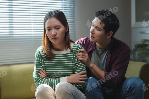 Preview: Young man comforting sad girlfriend at home
