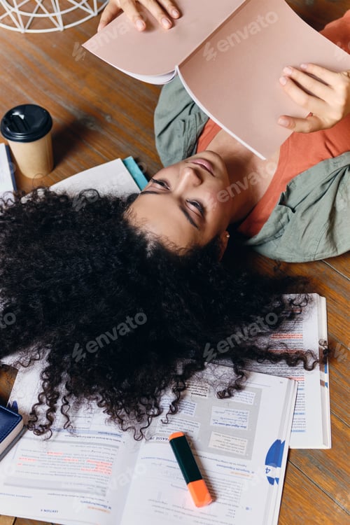 Preview: Relaxed Woman Studies on Floor Surrounded by Books