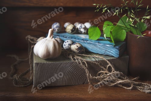 Preview: Beautiful still life. Garlic,quail eggs,jute rope on wooden boards,birch branch in a clay glass.