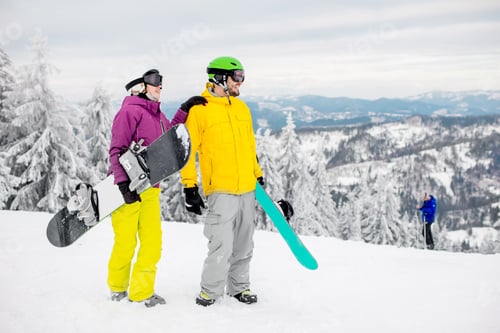 Vorschau: Paar mit Snowboards auf den verschneiten Bergen