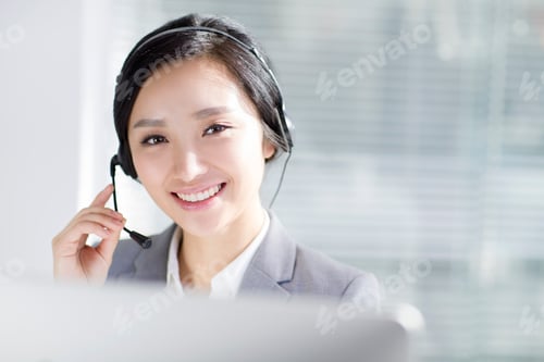 Preview: Businesswoman working in office with headset
