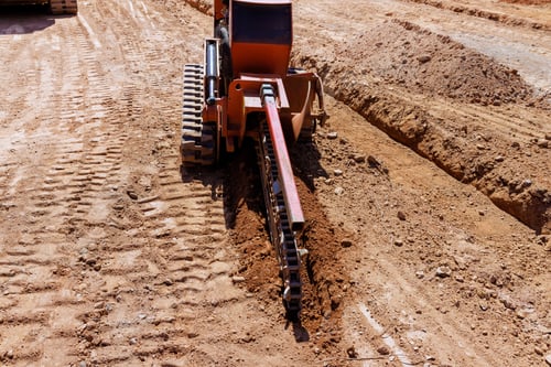 Preview: Construction equipment works on a dirt trench at a building site during daylight hours