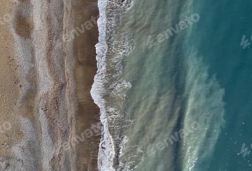Preview: Drone scenery of stormy ocean waves breaking on a sandy beach. Nature background.