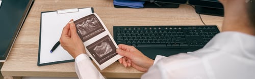 Preview: Back view of professional doctor radiologist analyzing scan MRI images in medical center