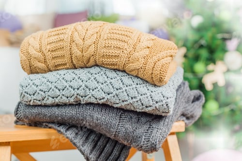 Preview: Stack of Sweaters with Christmas Tree Background