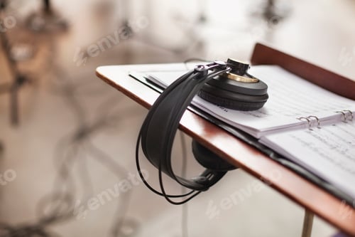 Preview: High angle view of headphones on musical sheet