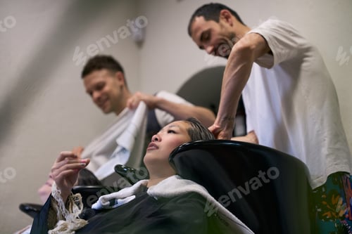 Preview: Hairdressers washing hair of young female model in salon