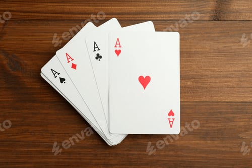 Preview: Four aces playing cards on wooden table, flat lay