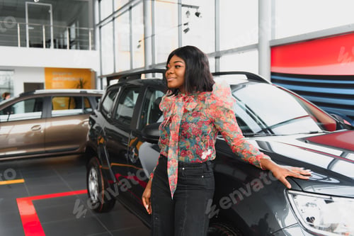 Preview: beautiful young african woman buying a car at dealership