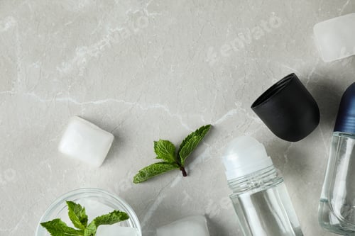 Vista previa: Flat lay composition with roll-on deodorants on light grey marble table