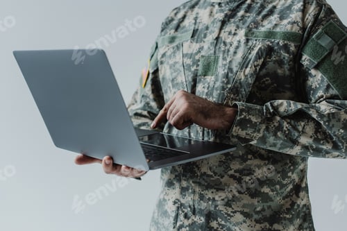 Preview: cropped view of soldier in army uniform using laptop isolated on grey