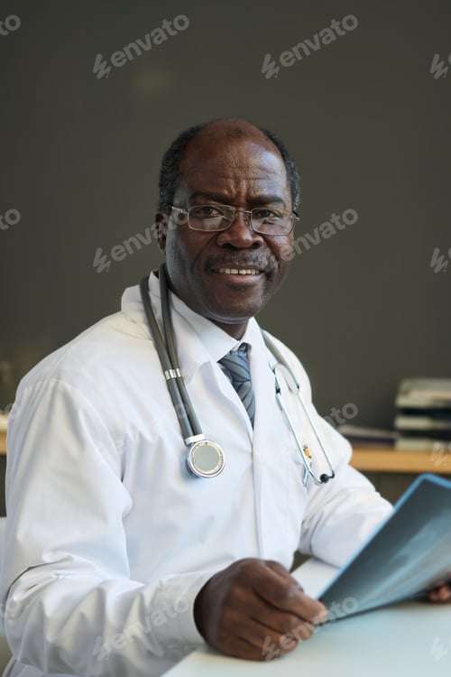 Preview: Experienced African American radiologist with lung x-ray result of patient looking at camera with