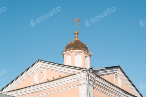 Preview: Church with golden dome and cross against clear blue sky. Exterior of an ancient religious
