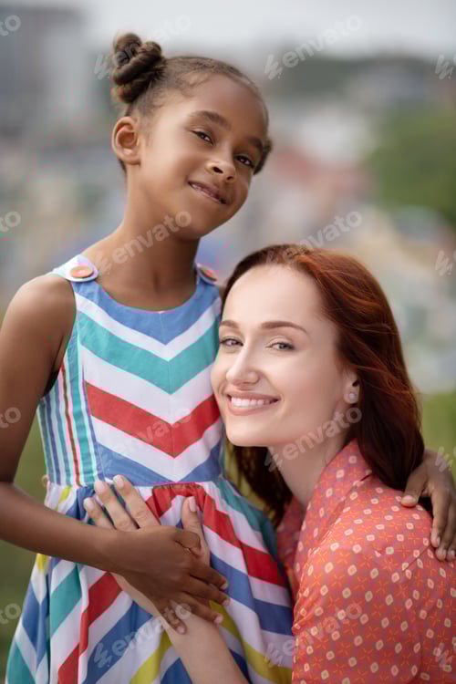 Preview: Adoptive mother standing near lovely daughter