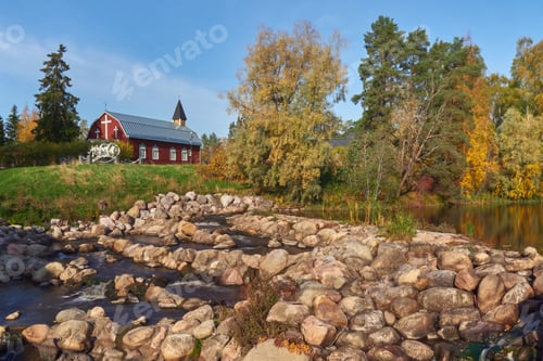 Preview: Autumn pond with rapids and church in Finland in Europe.