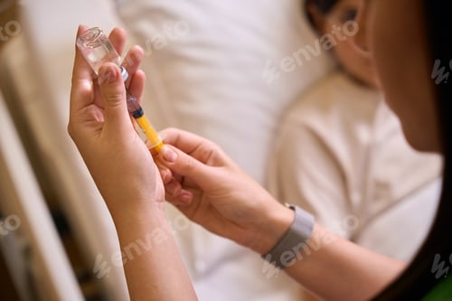 Preview: Health worker draws medicine into a syringe for injection