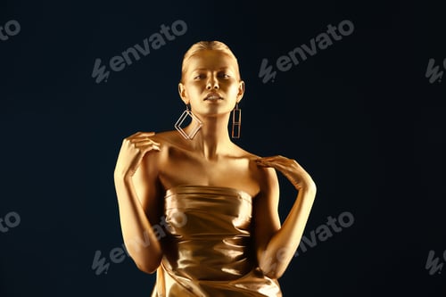 Preview: Portrait of beautiful lady with gold paint on skin against color background