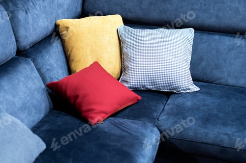 Preview: Closeup view of multicolor pillows on blue couch