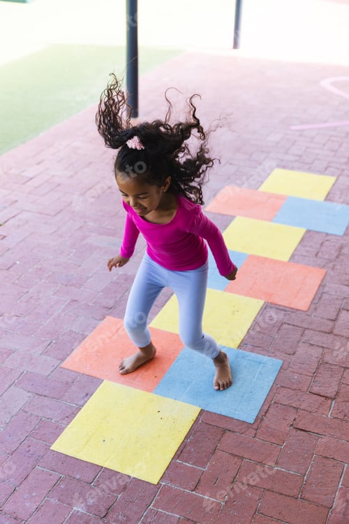 Preview: In school, young biracial girl is playing hopscotch alone outdoors