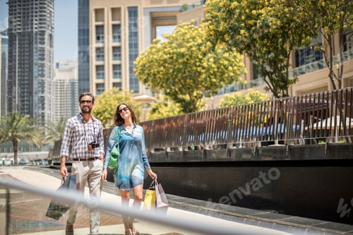 Preview: Couple strolling on walkway carrying shopping bags, Dubai, United Arab Emirates