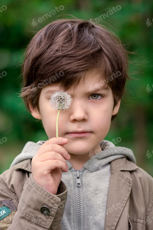 Preview: Child Holding Dandelion in a Green Outdoor Setting