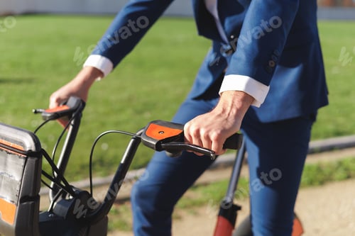 Preview: Close-up view of businessman hands riding a bike. Sustainable, eco-friendly and environment concept.