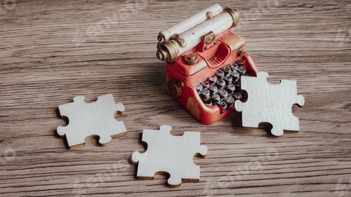 Preview: A miniature vintage typewriter surrounded by puzzle pieces,