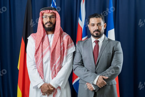Preview: Two intercultural delegates standing against flags of countries included in g7